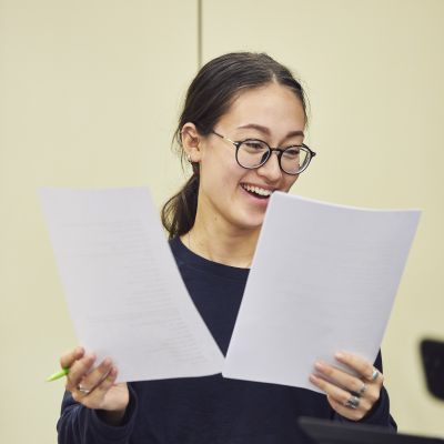 Singer holding two pieces of paper in a recording class